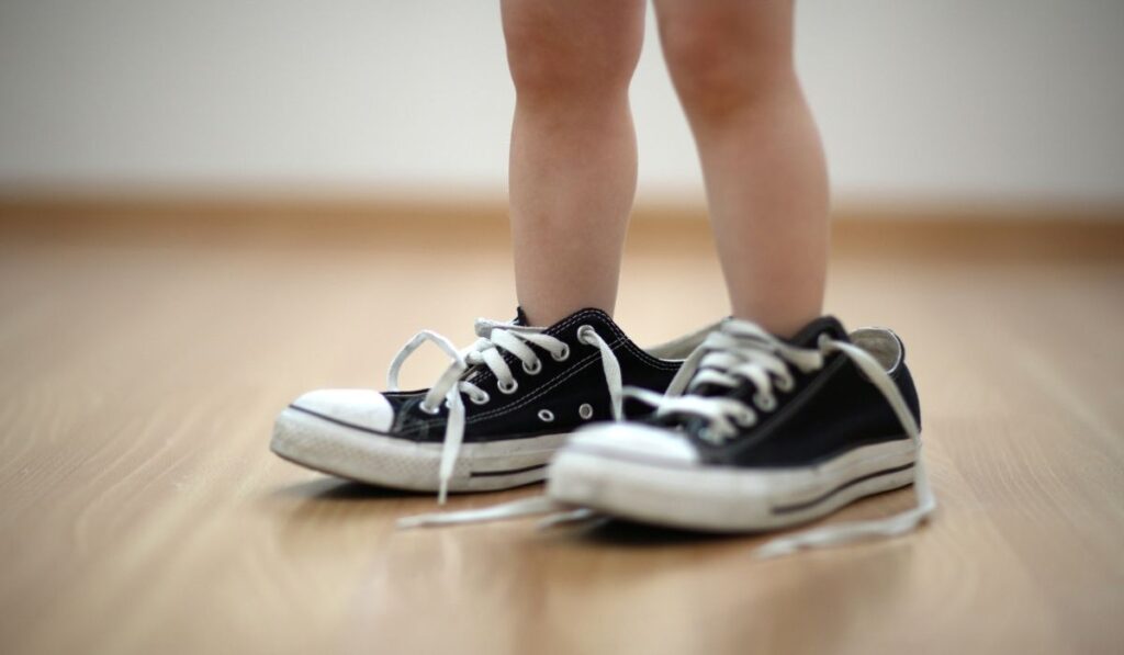 Child wearing adult persons shoes