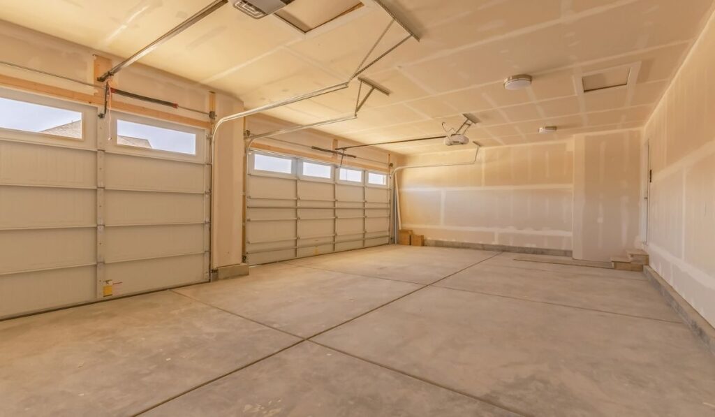 Interior of an empty garage with two large doors and small rectangular windows