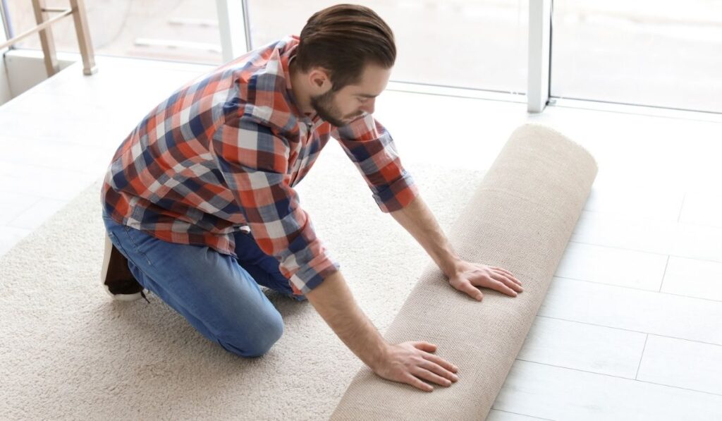 Man rolling out new carpet flooring