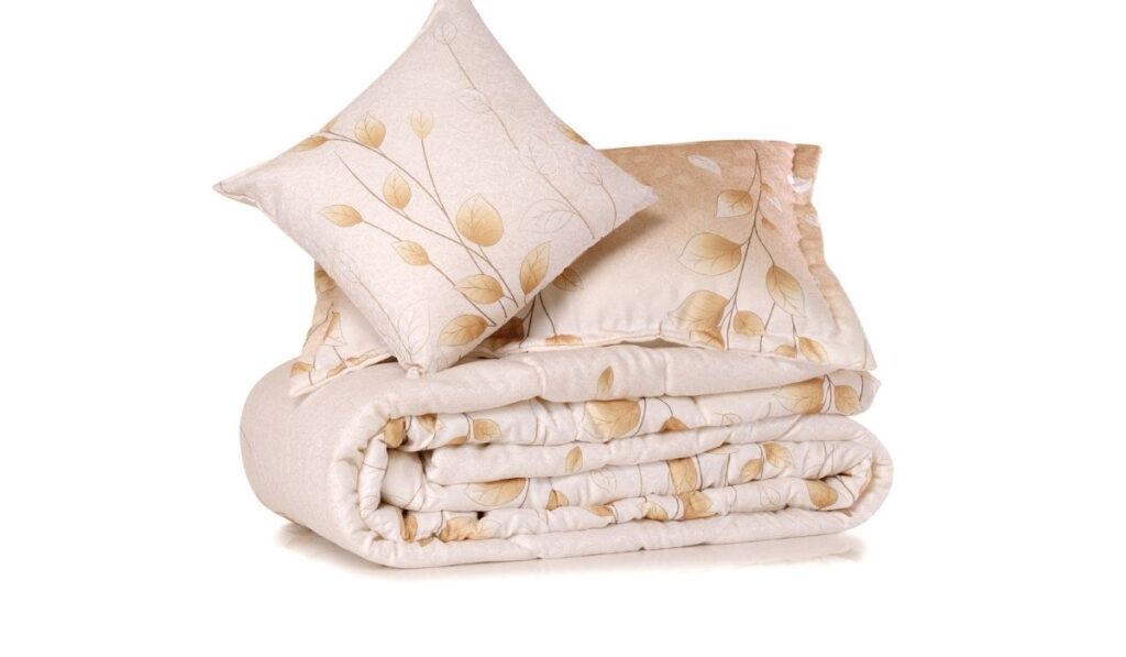 Soft pillows on comforter over white background
