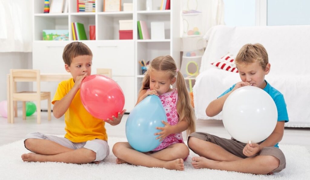 Kids blowing large balloons 