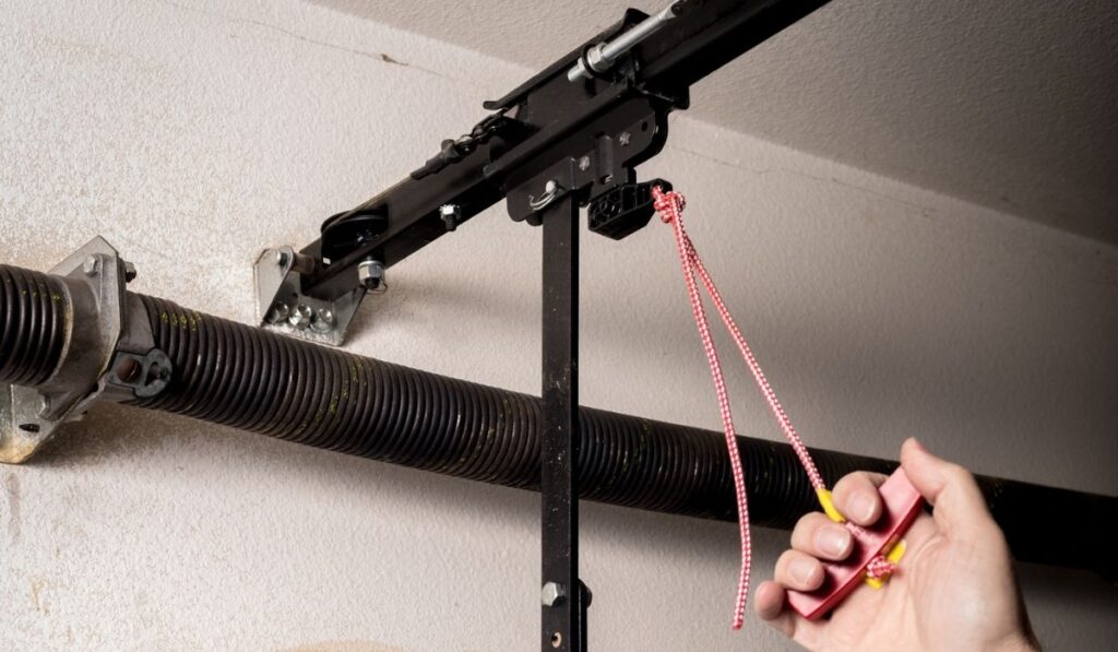 Man pulls the release cord to a garage door opener 