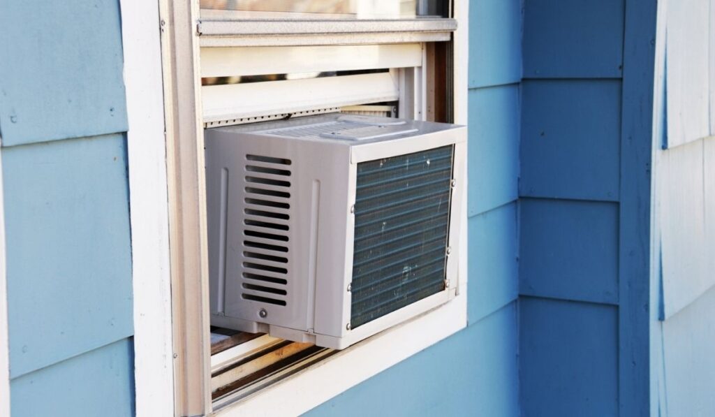 Old air conditioner installed on house window 