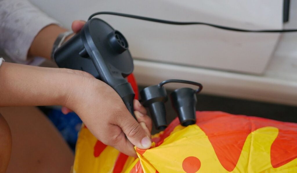 Woman`s hands holding and using mini air pump 