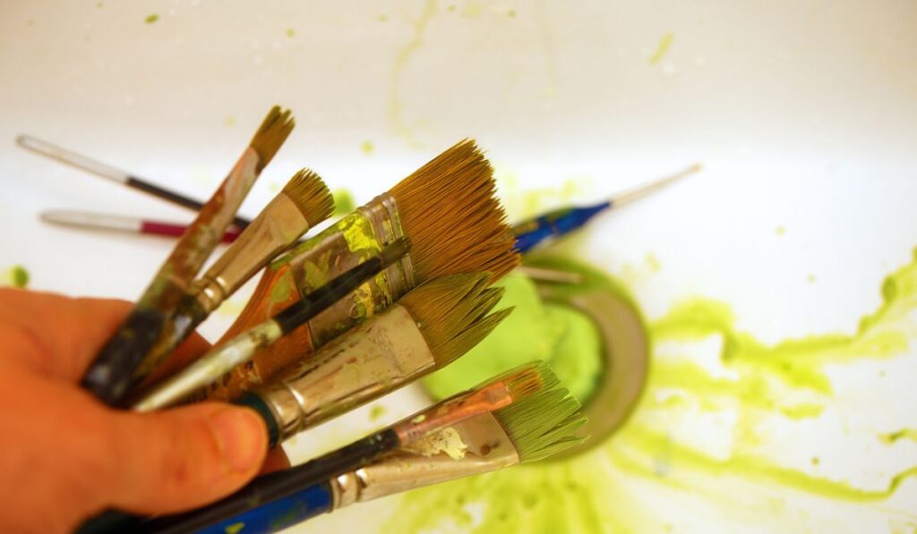 Cleaning Paint brushes in the sink by color 