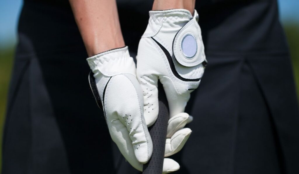 Golf player gloves hold the iron or putter