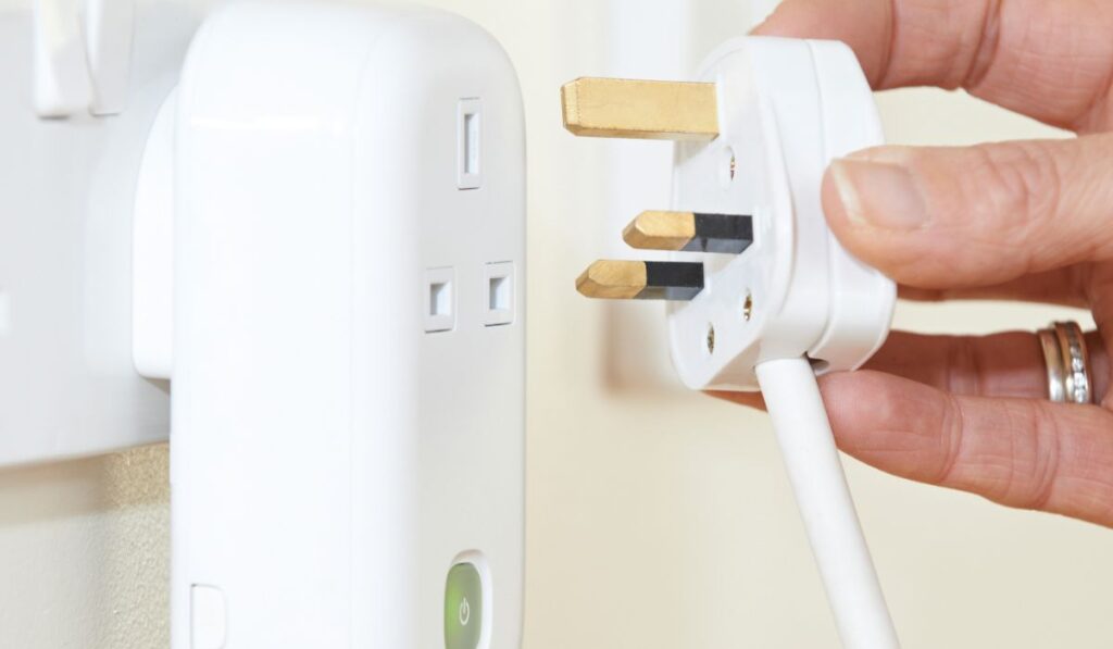 Woman Putting Plug Into Smart Electricity Socket