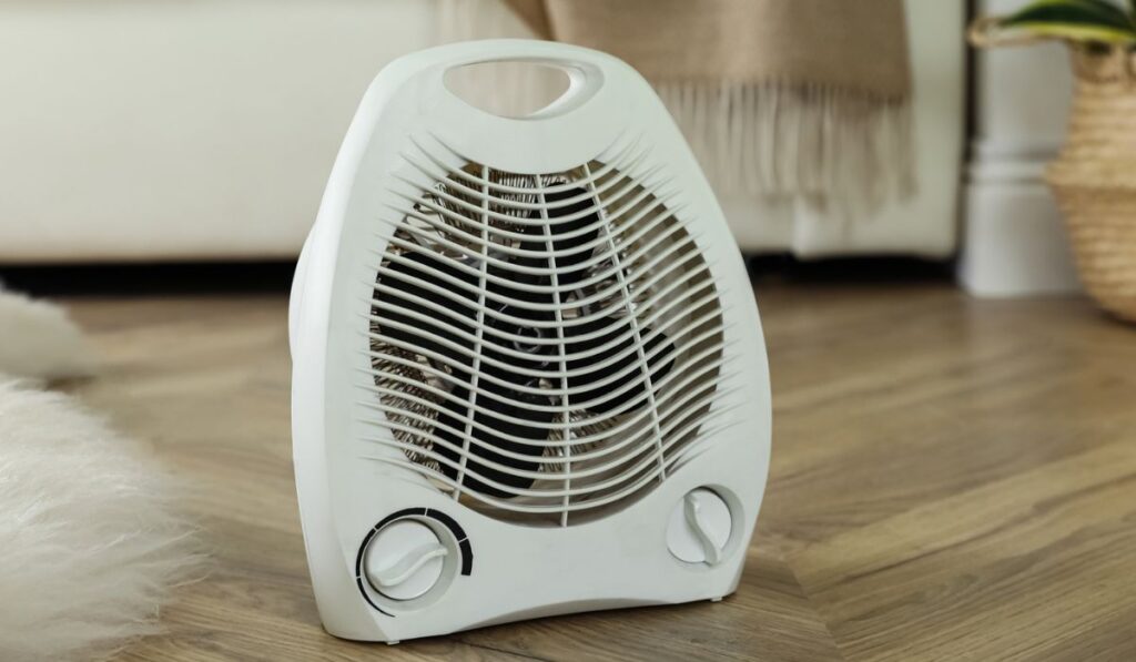 Modern electric fan heater on floor at home