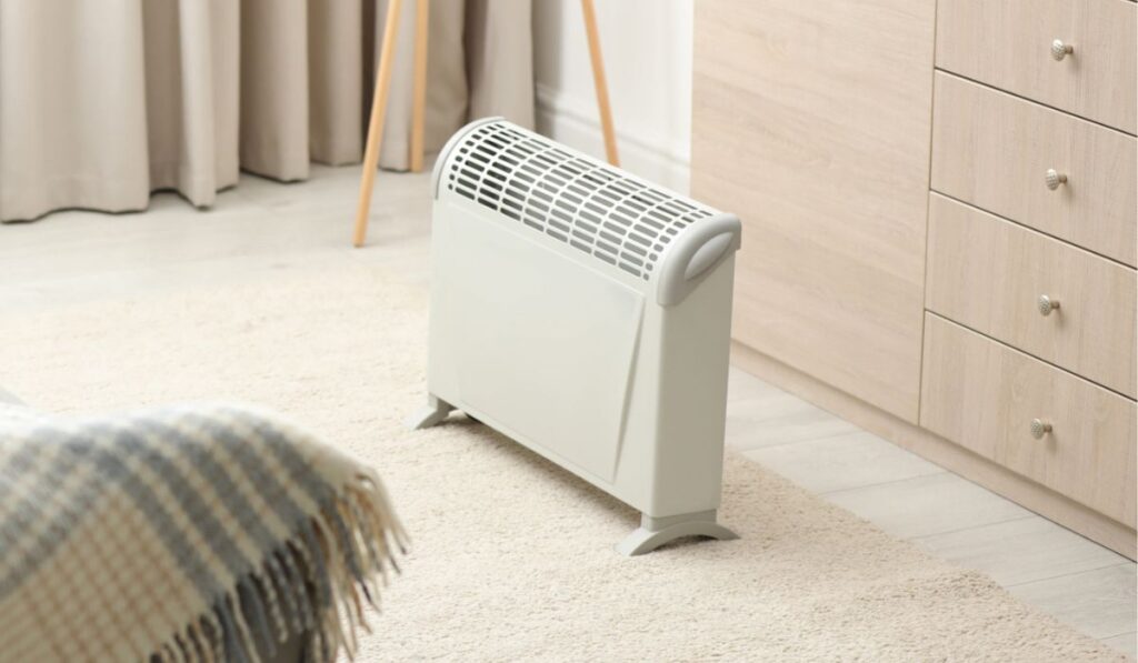 Modern electric heater in room interior 