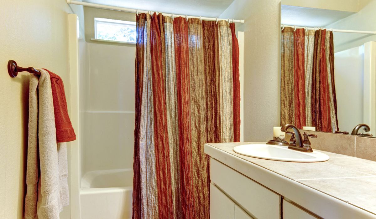 Simple bathroom with red and brown colors in shower curtain