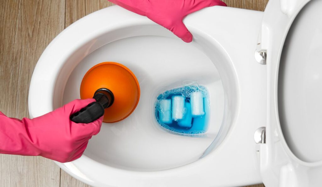 Women cleaning clogged toilet. broken overflowing toilet 