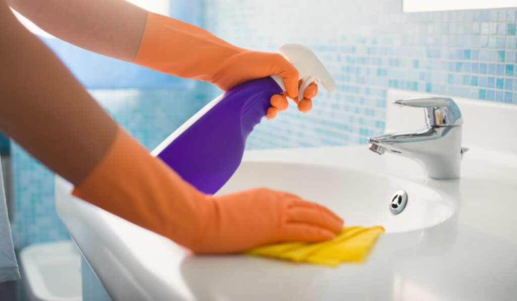 Woman doing chores cleaning bathroom at home